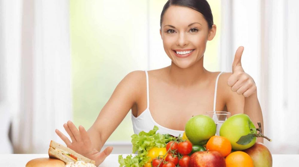 woman with fruits rejecting junk food healthy